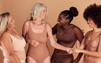 Four women looking at each other and laughing