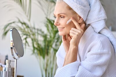 Old women putting on skincare